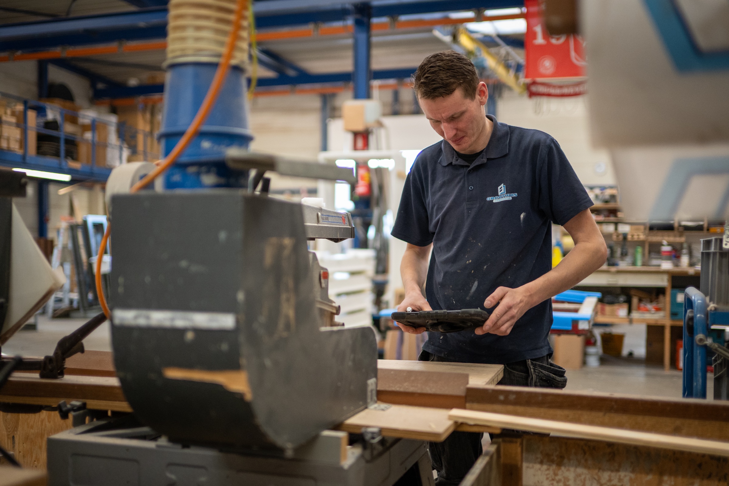 Medewerker met iPad bij schuurmachine